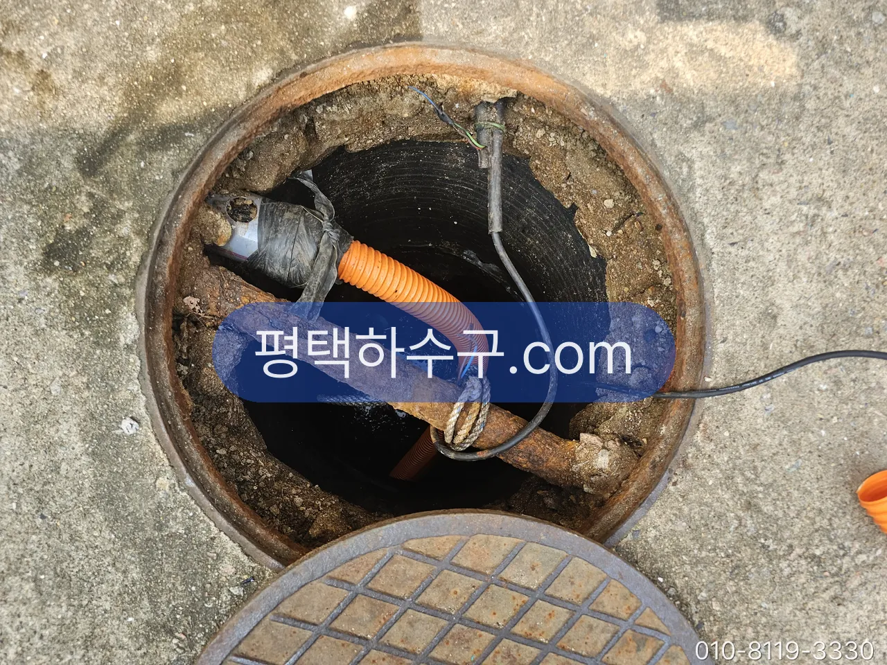 하수구 막힘 현장 — 마당 맨홀에서 막힌 구간을 확인하고 장비를 넣는 중